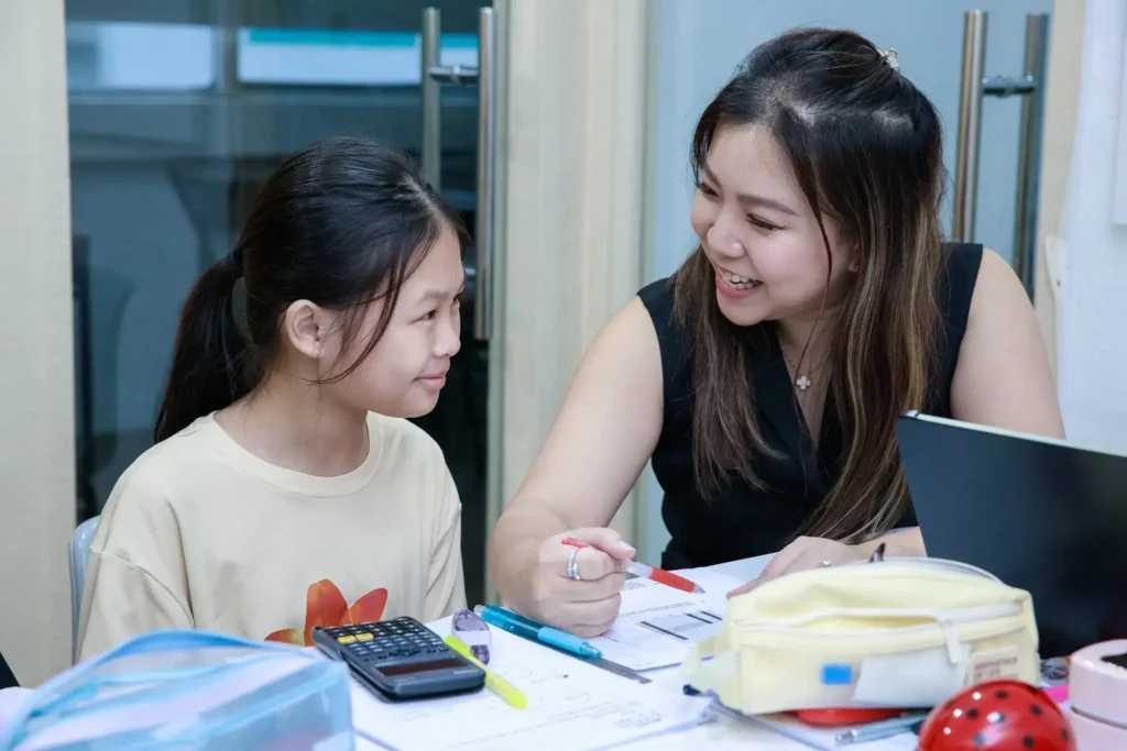 A student is studying with a teacher at a tuition centre