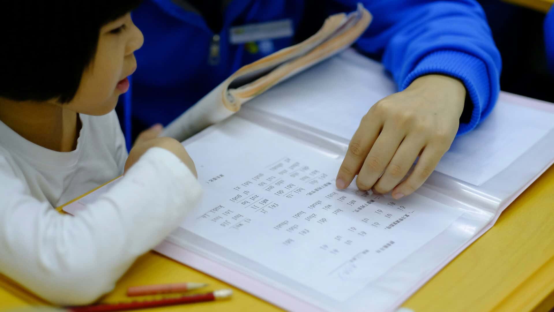 a child is studying with teacher at a tuition centre